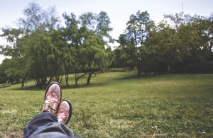 the shoes of someone lying in a green park