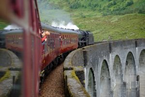 The Hogwarts Express train chugs along the track.