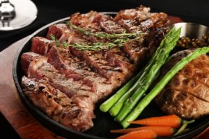 A steak dish with asparagus carrots, and potato.