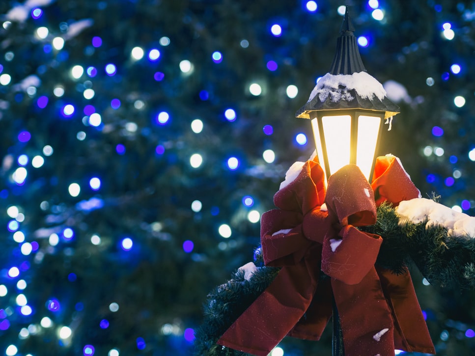 A light and tree decorated for a holiday event.