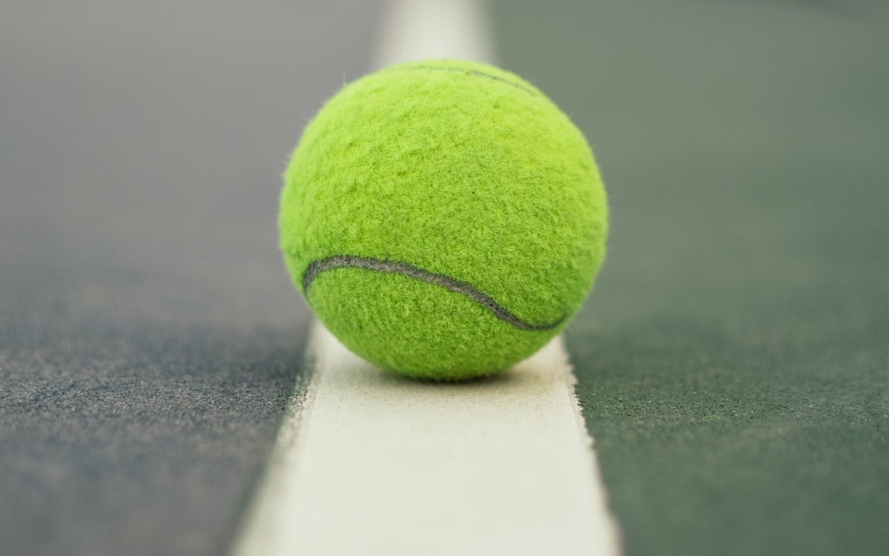 A tennis ball sits on a tennis court in Country Club Village.